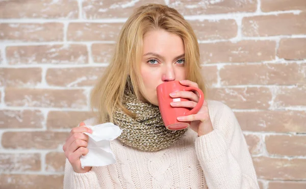 Runny nose and other symptoms of cold. Cold and flu remedies. Drink more liquid get rid of cold. Drinking plenty fluid important for ensuring speedy recovery from cold. Girl hold tea mug and tissue