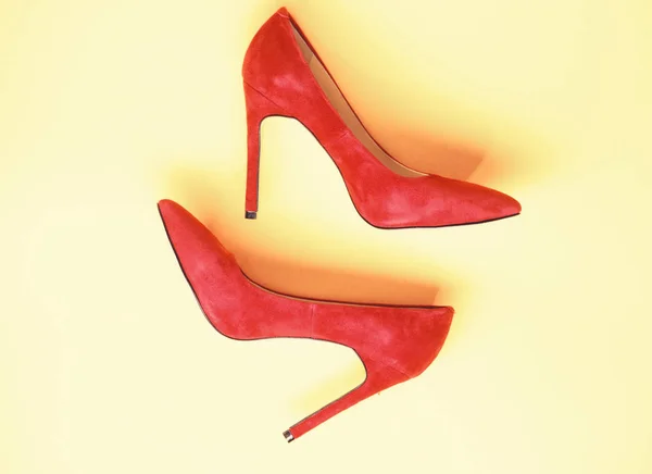 Concepto de zapatos femeninos. Calzado con tacones altos delgados, zapatos de aguja, vista superior. Zapatos fabricados en ante rojo sobre fondo amarillo. Par de zapatos de bomba de tacón alto de moda — Foto de Stock