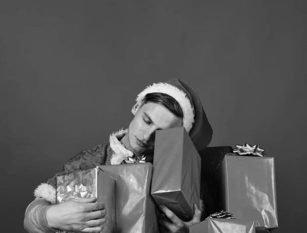 Adamın elinde Noel hediyeleri var. Hediyelerle dolu, gevşek yüzlü Noel Baba — Stok fotoğraf