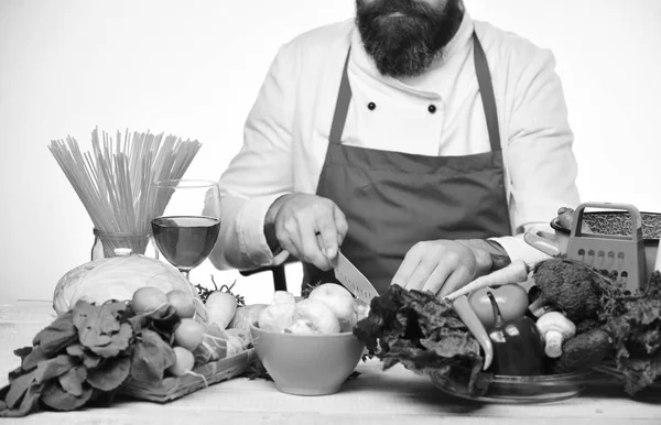 Cook with beard burgundy uniform cut vegetables. Professional cookery concept. — Stock Photo, Image