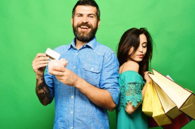 Sakallı adamın elinde kredi kartı ve para kutusu var.