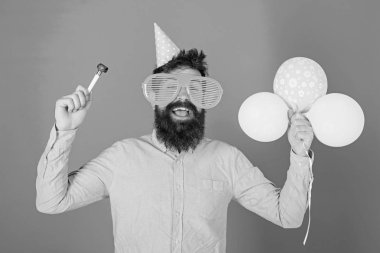 Sakal ve bıyık mutlu yüz tutan hava balonları, mavi arka plan üzerinde olan adam. Parti kavramı. Hippi dev gözlük Doğum günü kutluyor. Tatil öznitelikleri ile parti şapkalı adamı kutluyor