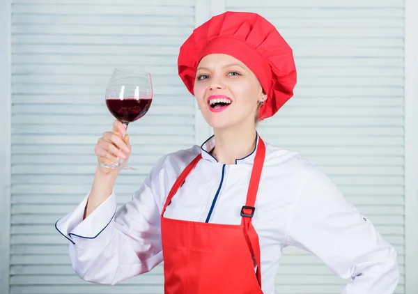 Exquisite dinner concept. Wine degustation. How to match wine and food like expert. Girl wear hat and apron enjoy aroma of drink. Woman chef hold glass of wine. Which wine to serve with dinner