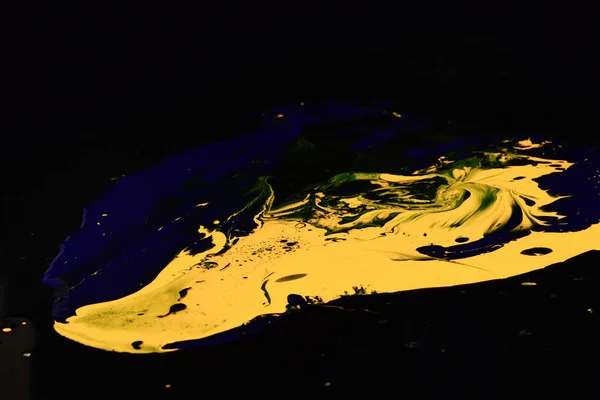 Pintura salpicando en la superficie oscura. Gotas de azul y amarillo — Foto de Stock