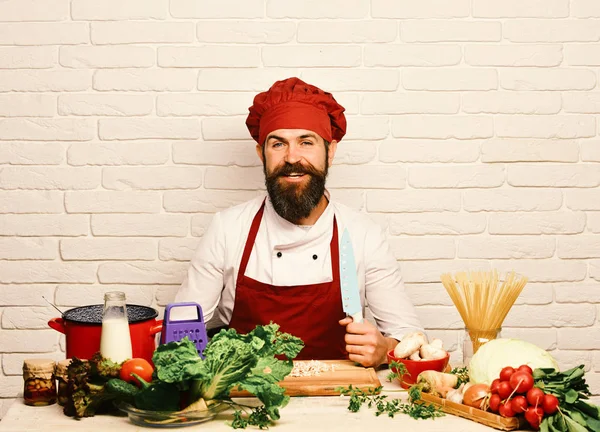 Restaurangkök. Man med skägg håller kniv på vit bakgrund — Stockfoto