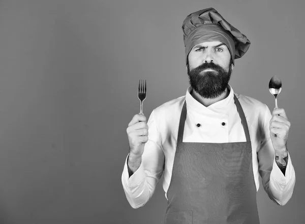 Chef heeft bestek. Koken met serieus gezicht in bordeaux uniform — Stockfoto