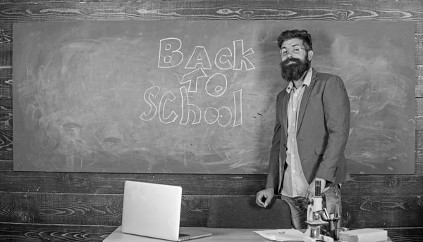 Teacher passionate job ability reach out students. Teacher near chalkboard holds chalk write inscription back to school. Man bearded teacher missed his work during vacation. Back to school concept — Stock Photo, Image