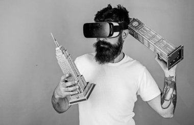 Adam Big Ben ve Empire State Binası tutar. Adam kendine güvenen yüzündeki mimarisi, 3d tasarım sanal gerçeklik oluşturma oluşturur. 3D tasarım konsepti. Vr gözlük, yeşil arka planda sakallı