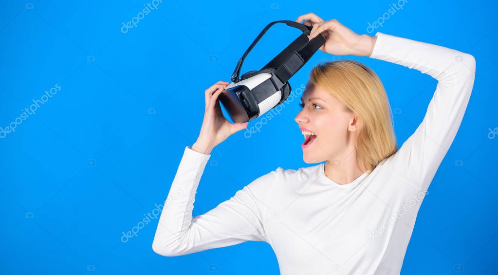 Portrait of young woman wearing VR goggles, experiencing virtual reality using 3d headset. Woman with virtual reality headset. Confident young woman adjusting her virtual reality headset and smiling.