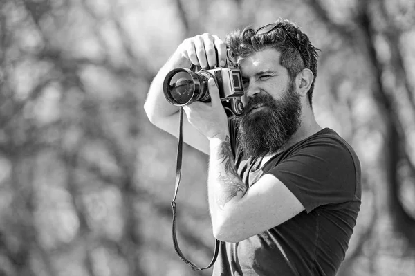 Genç erkek fotoğraf parkta vintage fotoğraf makinesi, hobi ve boş zaman etkinliği konsepti ile fotoğraf çekmek. Fotoğraf çekim için iyi bir yer ararken hipster sakallı