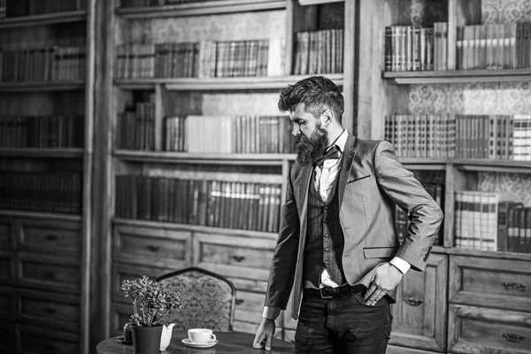 Law, advocacy, professional success, vintage concept. Lawyer stands in vintage interior near table with cup of tea or coffee. Bearded man in elegant suit in his cabinet. Avocat with thoughtful face — Stock Photo, Image