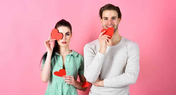 Conceito de sentimentos românticos. Dia dos Namorados e amor. Um homem bonito e uma rapariga bonita apaixonados. Homem e mulher casal no amor segurar cartões coração vermelho valentines no fundo rosa. Casal romântico apaixonado — Fotografia de Stock