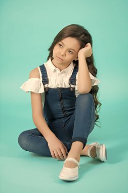 Ciddi yüz, mavi zemin üzerine uzun esmer saçlı kızla