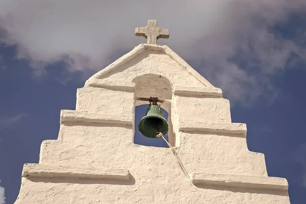 Zvonice se kříž v Mykonos, Řecko. Kaple stavebních detailů architektury. Bílý kostel na modrou oblohou. Koncept náboženství a kultu. Letní dovolená a cestování na středomořském ostrově — Stock fotografie