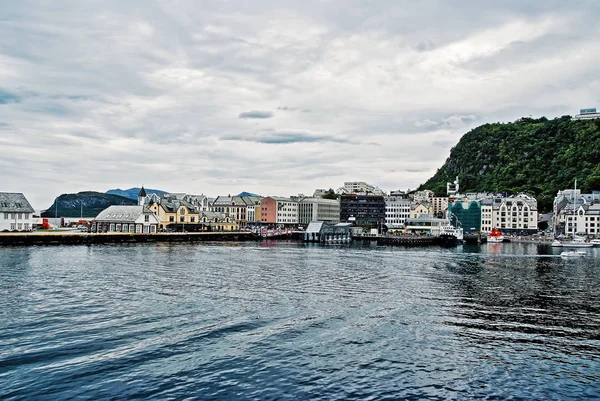 Architettura cittadina e montagna dall'acqua di mare ad Alesund, Norvegia — Foto Stock