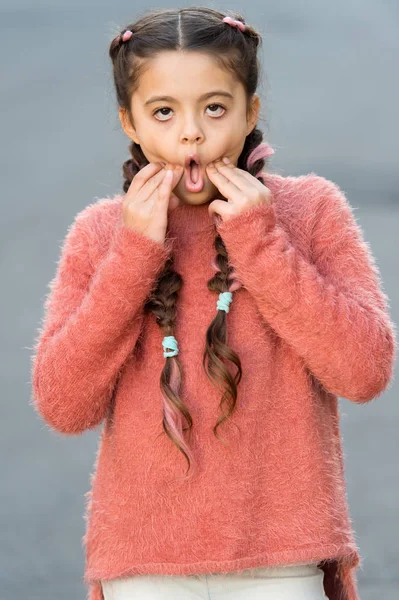 Il bambino con lunghi capelli intrecciati fa la faccia da smorfia annoiata. Che noia. Una ragazza annoiata che impazzisce. Gioca con le espressioni facciali. Una bambina completamente annoiata. Creare svago interessante o intrattenimento. Cose noiose — Foto Stock