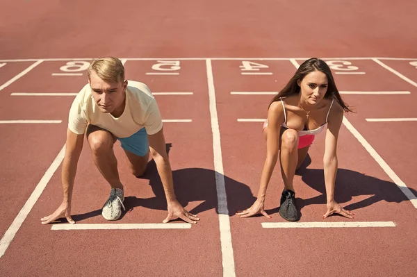Sportpaar startet Wettkampflauf auf Arena-Bahn — Stockfoto