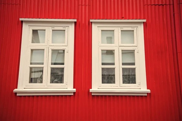 Fenêtres dans la maison à Reykjavik, en Irlande. Façade du bâtiment avec mur rouge et cadres de fenêtre blancs. Structure et conception architecturales — Photo