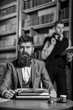 Bir daktiloda yazmaya konsantre yüzle sakallı yazar