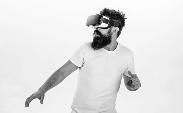 Hipster on scared face exploring virtual reality with modern gadget. Man with beard in VR glasses run away , white background. VR game concept. Guy with head mounted display run in virtual reality