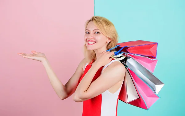 Meisje geniet van winkelen of net verjaardagsgiften. Vrouw rode jurk greep bos boodschappentassen blauw roze achtergrond. Tips om winkel verkoop met succes. Koop alles wat die je wilt. Meisje tevreden met winkelen — Stockfoto