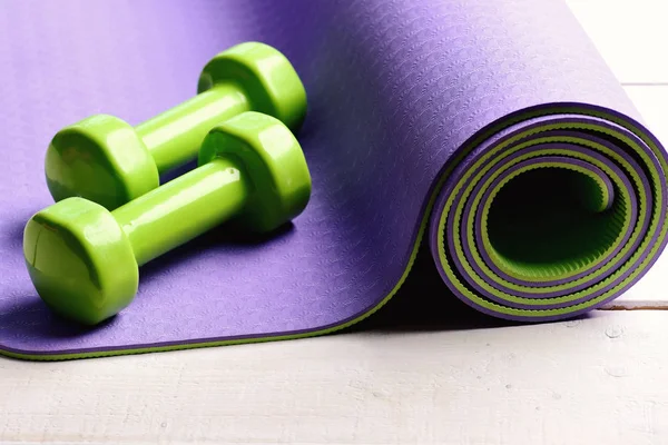 Formarea și echipamentul de fitness. Barbells culcat pe covor de yoga violet . — Fotografie, imagine de stoc