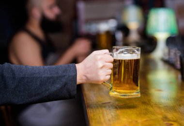 Bira bardağı bar sayaç üzerinde arka plan defocused. Taze bira fıçı bira ile köpük bardak. Erkek el tutar ile lezzetli bira dolu bardağı çubuk. Cuma Eğlence geleneği. Bira pub konsepti
