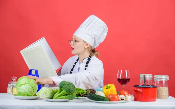 Kvinna i hatt och förkläde vet allt om måltidskunskap. Förbättra matlagning skicklighet. Kulinarisk expert. Kvinna kock Matlagning hälsosam mat. Flicka läsa boken bästa kulinariska recept. Kulinariska utbildning koncept — Stockfoto