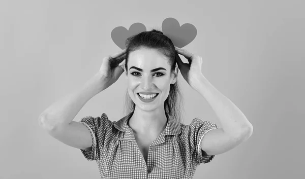 Coquetear, emociones, San Valentín, concepto de buen humor. Chica con la cara alegre, maquillaje y corazones rojos. Mujer en vestido elegante tiene símbolos románticos. Lleno de amor. Chica feliz sonríe con corazones de San Valentín — Foto de Stock