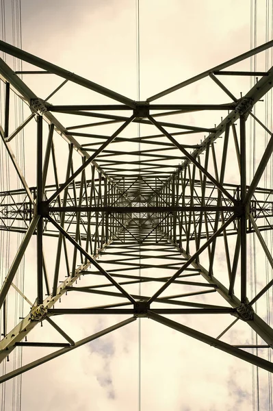 Transmission tower underifrån. Power tower på molnig himmel. El pylon struktur för kraftledning. Högspänning post utomhus. Energi och ekologi — Stockfoto