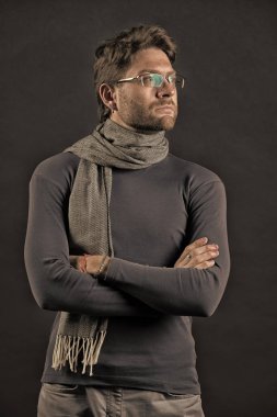 Adam eşarp ve katlanmış ellerle kazak