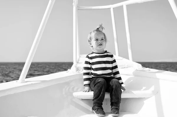 Un joven viajero. Niño lindo yate marinero día soleado. Niño adorable marinero camisa a rayas yate blanco viajar por todo el mundo. Aventura de niño marinero viajando mar. Bebé niño disfrutar de vacaciones en crucero —  Fotos de Stock