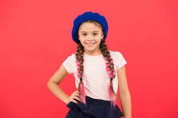 Moda adolescente. Atributo de la moda francesa. Niño niña pequeña feliz bebé sonriente. Niña pequeña linda chica de moda posando con trenzas largas y sombrero fondo rojo. Chica de moda. Accesorio de boina de moda —  Fotos de Stock