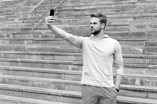 Selfie concept. Handsome man take selfie with smartphone. Athletic guy use mobile phone for selfie. Selfie before training