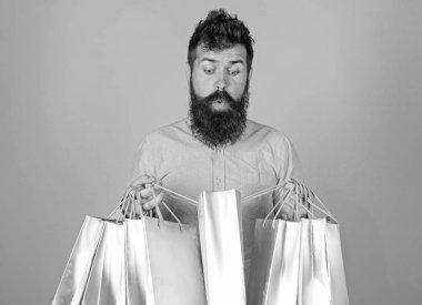 Satış ve indirim kavramı. Şok yüz bağımlısı alışveriş veya Alışverişkoliğin hippi. Satış sezon indirimlerle alışveriş adam. Sakal ve bıyık taşımak alışveriş torbaları, açık mavi renkli olan adam