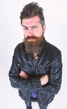 Sakal ve bıyık kameraya bakarak sıkı yüzünde olan adam. Maço deri ceket, beyaz arka plan giyer. Hipster şık kıyafetiyle poz ciddi görünüyor. Erkek Giyim ve moda kavramı