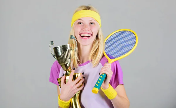 First place. Sport achievement. Celebrate victory. Tennis champion. Athletic girl hold tennis racket and golden goblet. Win tennis game. Tennis player win championship. Woman wear sport outfit