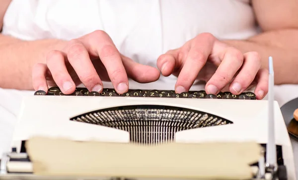 Vintage typewriter concept. Hands typing retro writing machine. Old typewriter and authors hands. Male hands type story or report using white vintage typewriter equipment close up. Writing routine