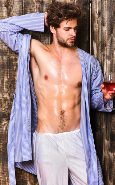 Drink wine and relax. Bachelor enjoy wine. Erotic and desire concept. Guy attractive relaxing with alcohol drink. Man sexy chest sweaty skin hold wineglass. Macho tousled hair degustate luxury wine