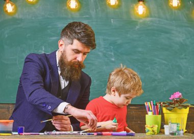 Baba ve oğul, sanat sınıfı. Baba oğlu için fırçalar tutarak. Yaratıcılığı geliştirmek