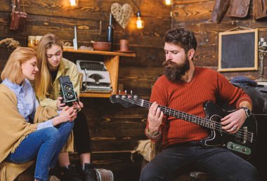 Elektrik gitar çalmak kesilmiş sakallı adam. Kırsal kesimde aile ile vakit müzisyen. Sakallı adam evde prova. Kızlar ünlü besteci hakkında belgesel.