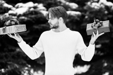 Kışın açık havada hediye kutusu olan yakışıklı bir adam.