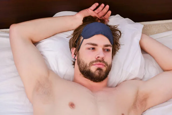 Pies de hombre durmiendo en una cama cómoda. Imagen que muestra a un joven estirándose en la cama. Reloj despertador con un hombre durmiendo en la cama . —  Fotos de Stock