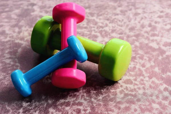 Barbell ahşap yüzey üzerinde yeşil, pembe ve mavi renkte