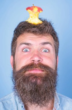 Hipster mutlu yüz baş mavi arka plan, elma güdük hedef ile kapatın. Adam yakışıklı hipster uzun sakal neredeyse kafasına elma güdük hedef olarak yem. Kilo kaybı gol. Canlı hedef kavramı