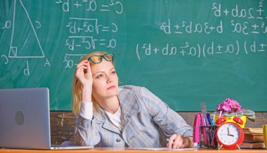 Öğretmen kadın tablo sınıf kara tahta arka plan otur. Öğretmen evrak ile meşgul. Çok gerçek okul gün çalışıyorum. Öğretmen sınıfları sonra yüz tutmak çalışma yorgun. İşkolik uykulu işyerinde