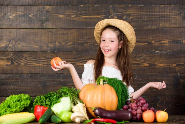 Actividades de granja para niños. Mercado agrícola tradicional. El niño celebra la cosecha. Mercado de granja para niñas con cosecha de otoño. Niño agricultor con fondo de madera de la cosecha. Familia granja festival concepto — Foto de Stock