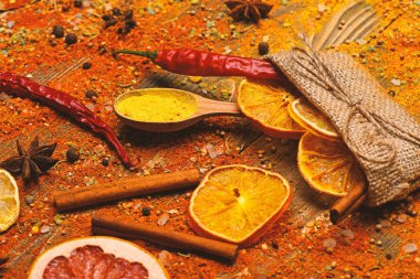 Baharat tüm ahşap yüzey üzerinde dağınık. Tarçın, öğütülmüş kırmızı biber ve curcuma toz ve mutfak otlar dolu kaşık masa üzerinde dağınık. Baharat kavramı. Ahşap doku baharat kaşıklarla
