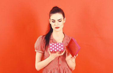 Hayal kırıklığı, kötü hediye, Doğum günü, kadının gün, Noel, alışveriş kavramı. Üzgün yüz, kız makyaj ve pack pink. Şık elbiseli kadın mevcut açılır. Hediye izole kırmızı bayanla