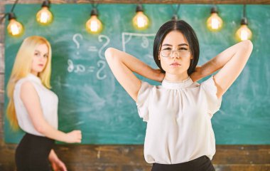 Öğrenci ve kursiyer kavramı. Çekici bir kadın ders için hazırlanıyor. Kız çekici Bayan defocused kara tahta arka plan üzerinde yazma sırasında görünüyor. Öğrenci, Öğretmen sınıfta gözlük standı